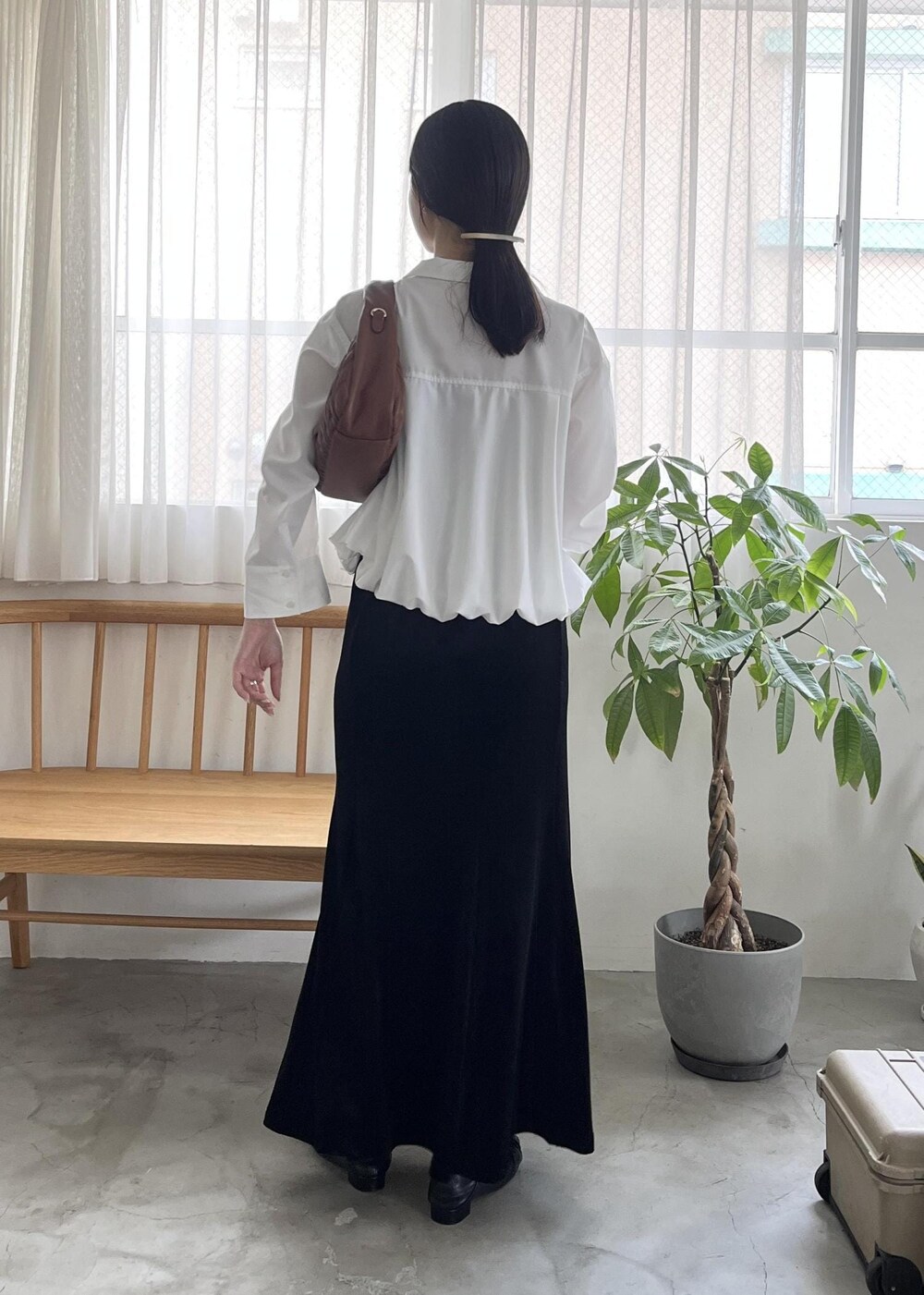 ブラック系のパンプス、ブラウン系のハンドバッグ、ホワイト系のシャツ/ブラウスを着用したレディースの秋コーディネートの4枚目の写真