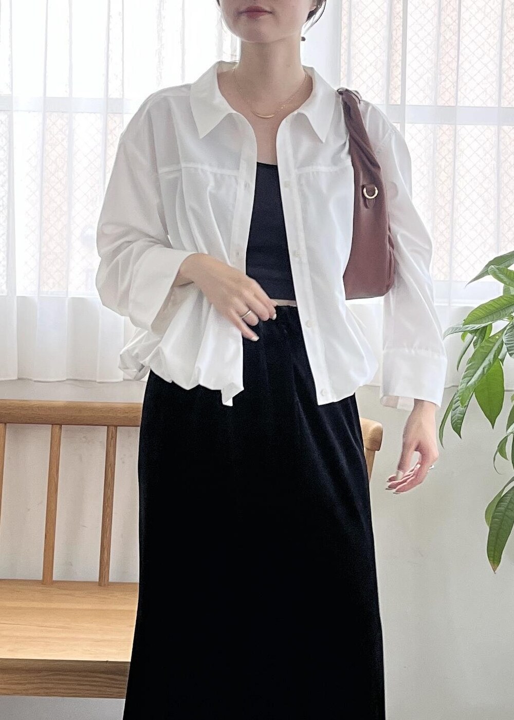 ブラック系のパンプス、ブラウン系のハンドバッグ、ホワイト系のシャツ/ブラウスを着用したレディースの秋コーディネートの5枚目の写真