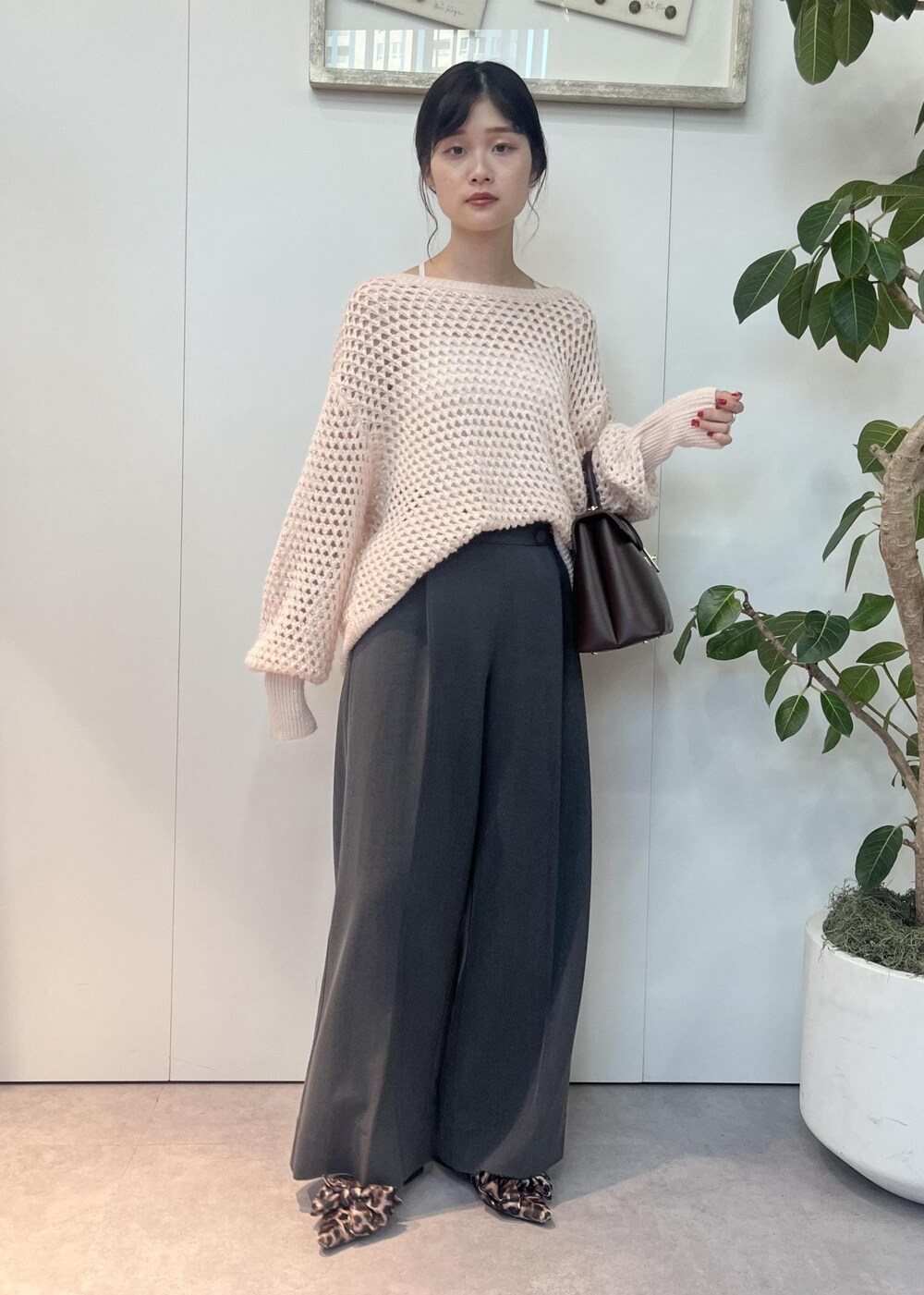 ブラウン系のハンドバッグ、その他のサンダル、ピンク系のニット/セーターを着用したレディースの秋コーディネートの2枚目の写真