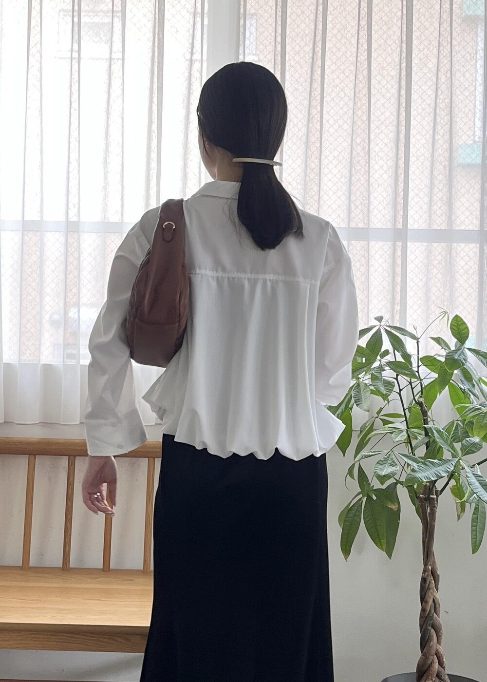 ブラック系のパンプス、ブラウン系のハンドバッグ、ホワイト系のシャツ/ブラウスを着用したレディースの秋コーディネートの7枚目の写真