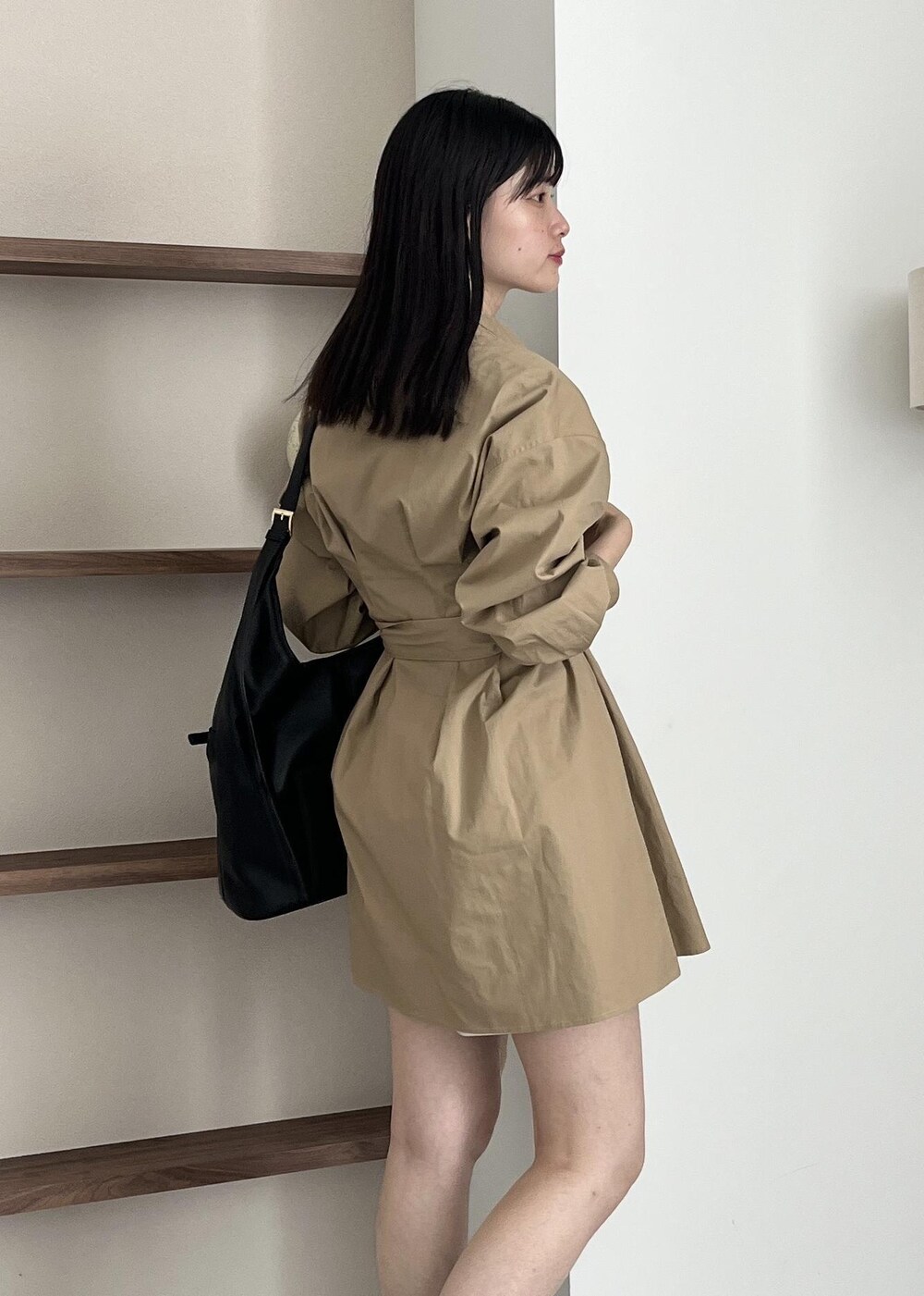 ブラック系のブーツ、ブラック系のショルダーバッグ、ベージュ系のワンピースを着用したレディースの夏コーディネートの6枚目の写真