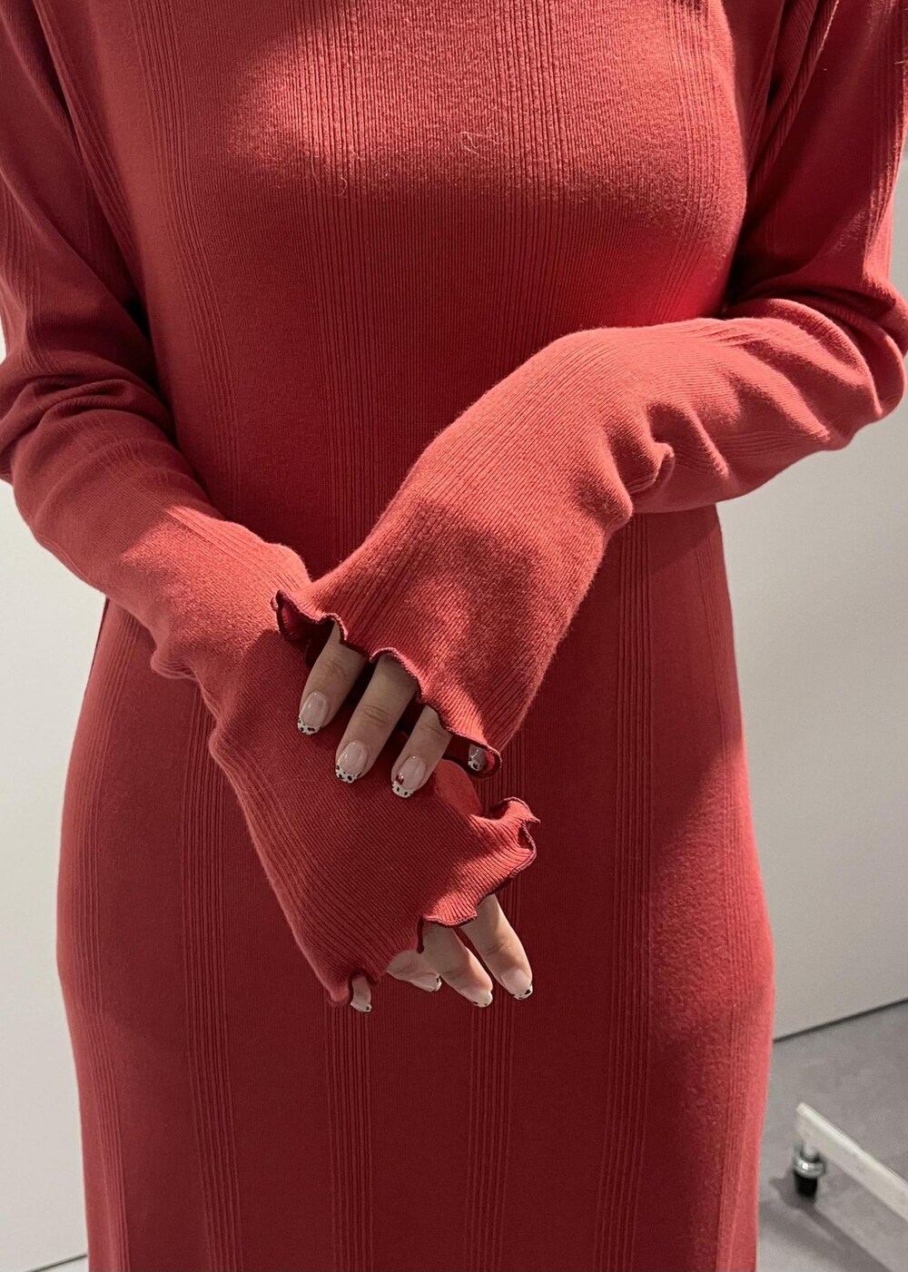 ベージュ系のドレスシューズ、レッド系のワンピース、ホワイト系のカーディガン/ボレロを着用したレディースの秋コーディネートの6枚目の写真