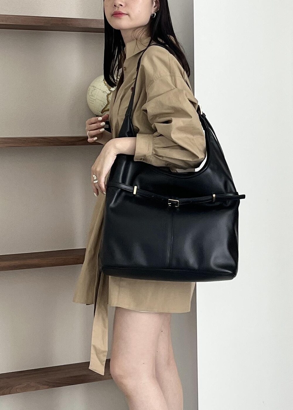 ブラック系のブーツ、ブラック系のショルダーバッグ、ベージュ系のワンピースを着用したレディースの夏コーディネートの7枚目の写真