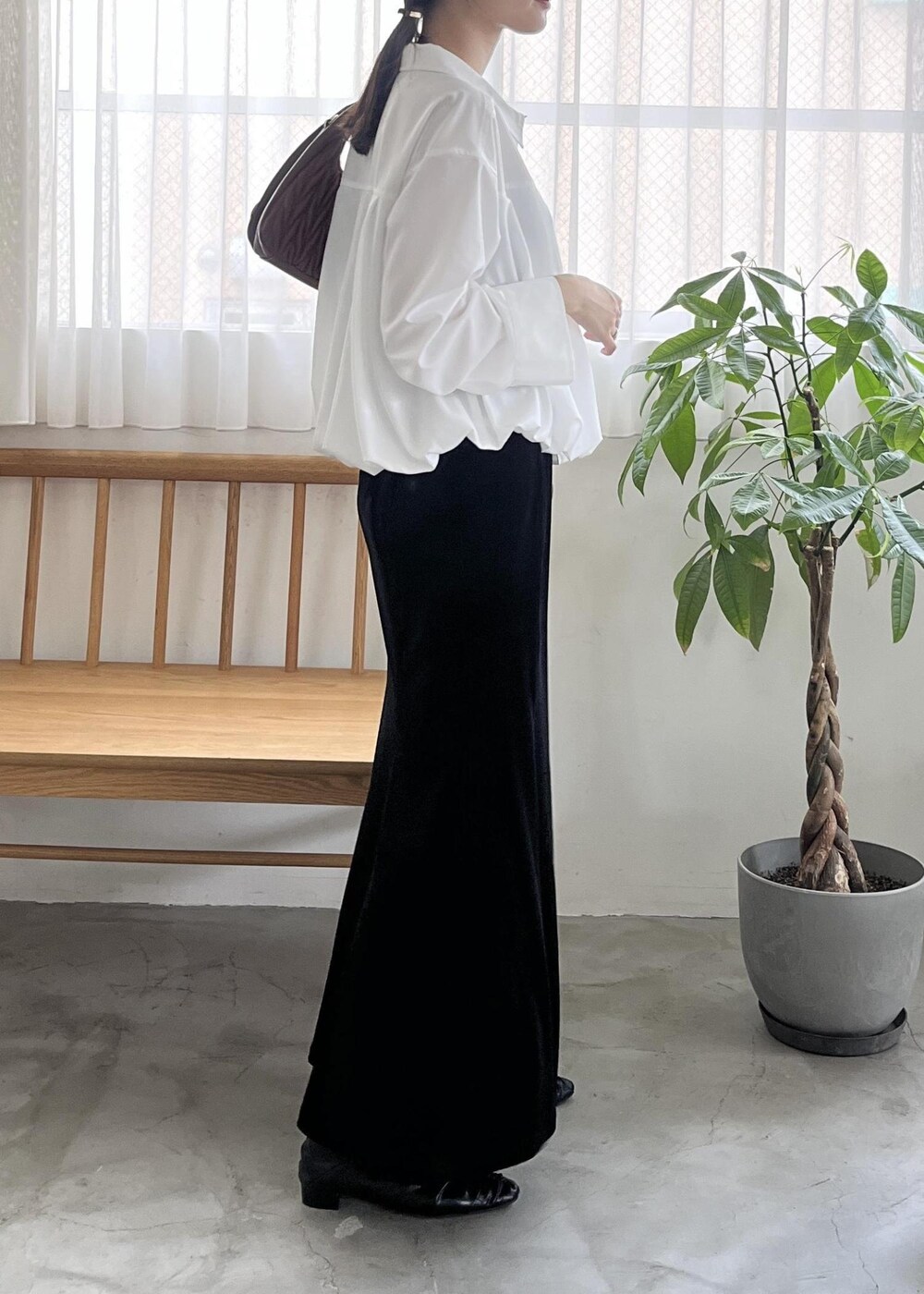 ブラック系のパンプス、ブラウン系のハンドバッグ、ホワイト系のシャツ/ブラウスを着用したレディースの秋コーディネートの3枚目の写真