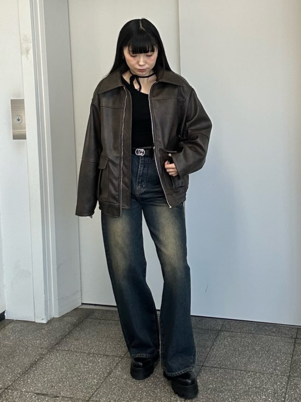 ブラック系のブーツ、ブルー系のデニムパンツ、ブラック系のニット/セーターを着用したレディースの冬コーディネートの6枚目の写真