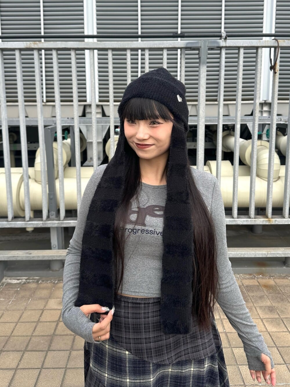 ブルー系のスカート、ブラック系のブーツ、グレー系のTシャツ/カットソーを着用したレディースの秋コーディネートの5枚目の写真