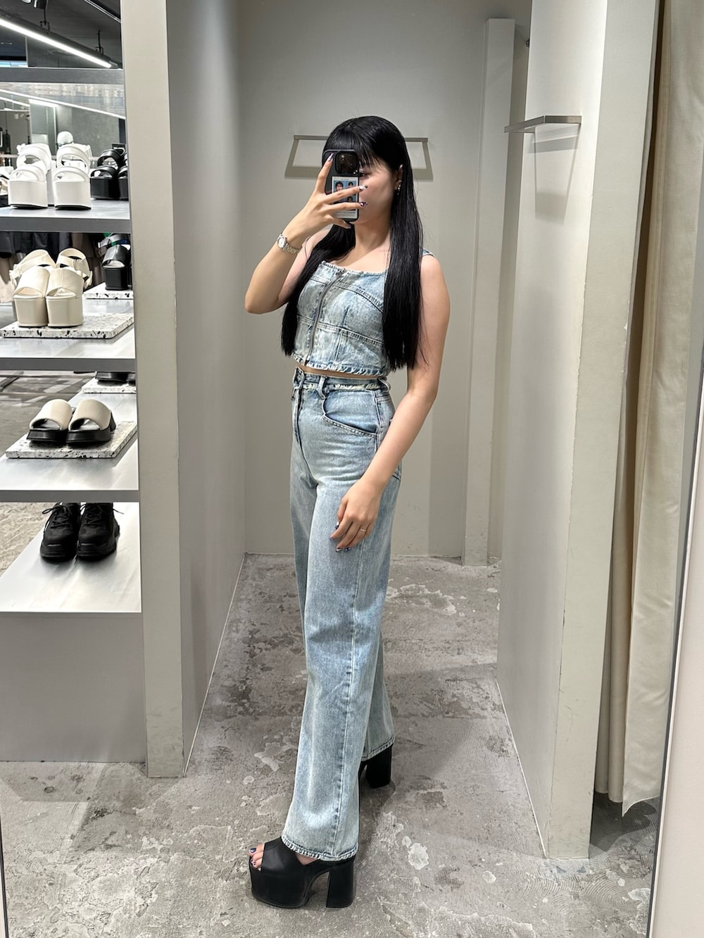 ブルー系のデニムパンツ、ブルー系のキャミソール、ブラック系のサンダルを着用したレディースの夏コーディネートの2枚目の写真