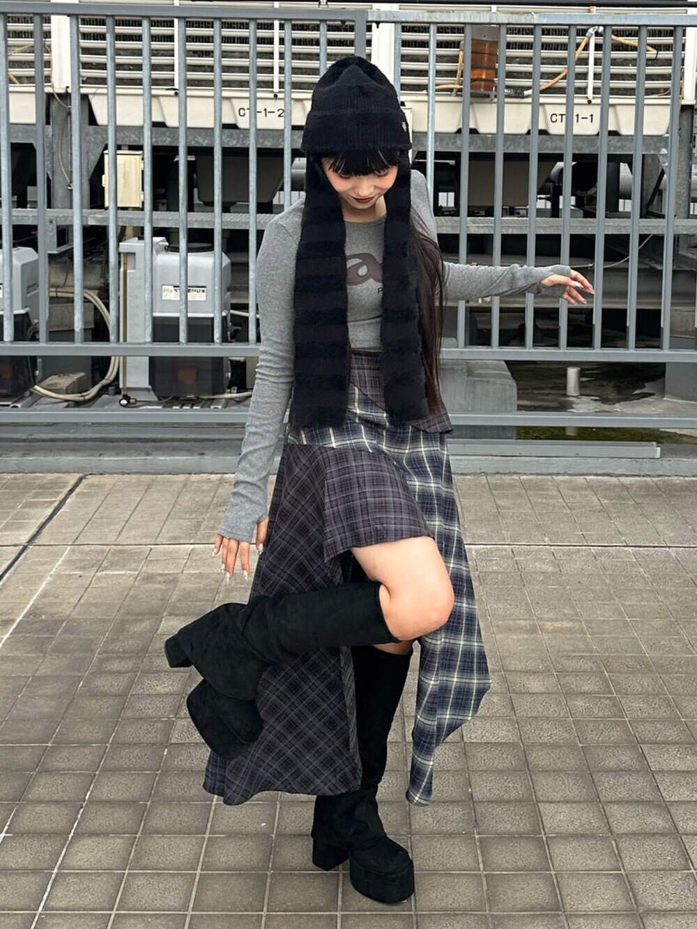 ブルー系のスカート、ブラック系のブーツ、グレー系のTシャツ/カットソーを着用したレディースの秋コーディネートの4枚目の写真