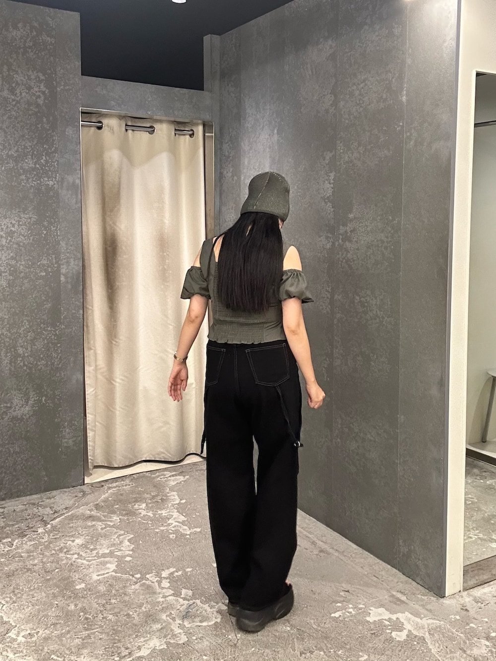 ブラック系のデニムパンツ、グリーン系のTシャツ/カットソー、ブラック系のサンダルを着用したレディースの夏コーディネートの3枚目の写真