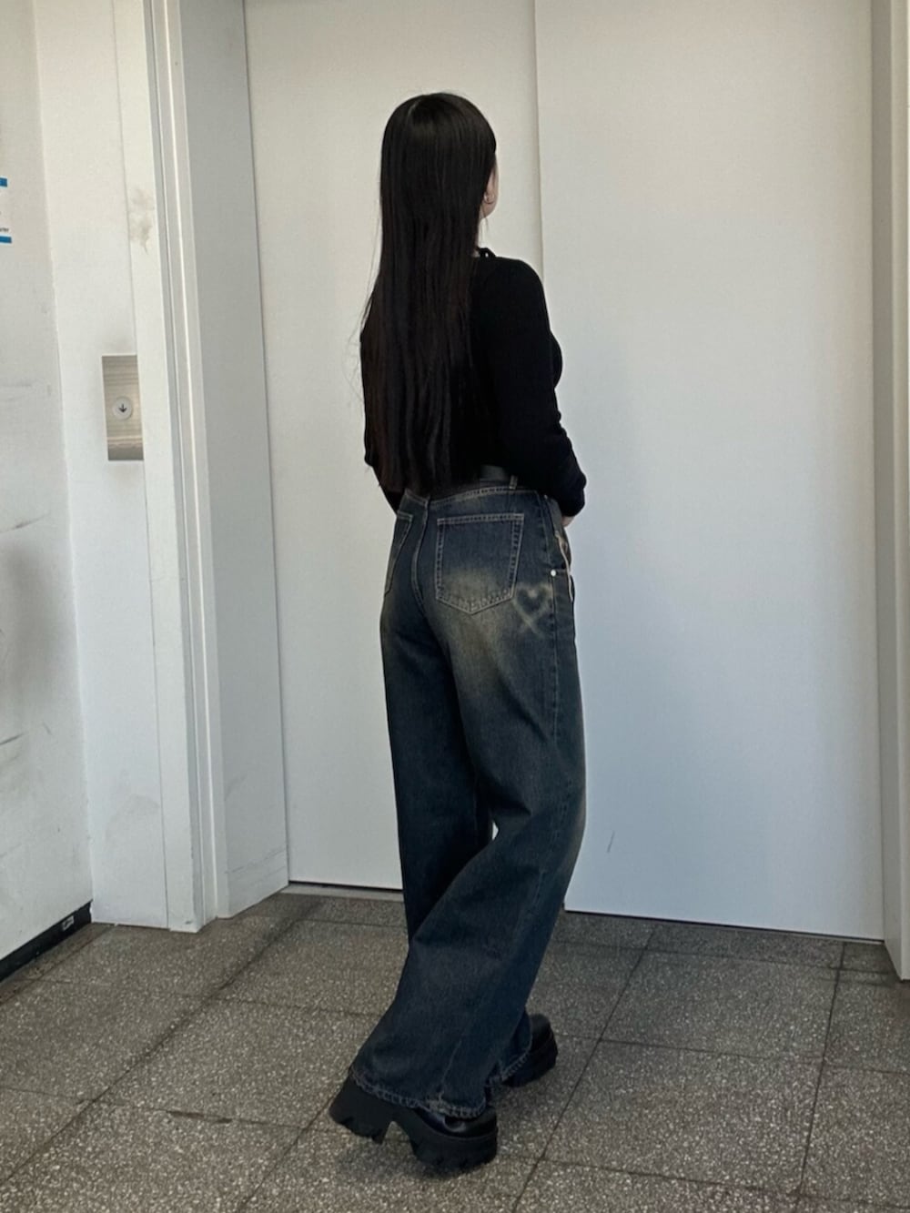 ブラック系のブーツ、ブルー系のデニムパンツ、ブラック系のニット/セーターを着用したレディースの冬コーディネートの4枚目の写真