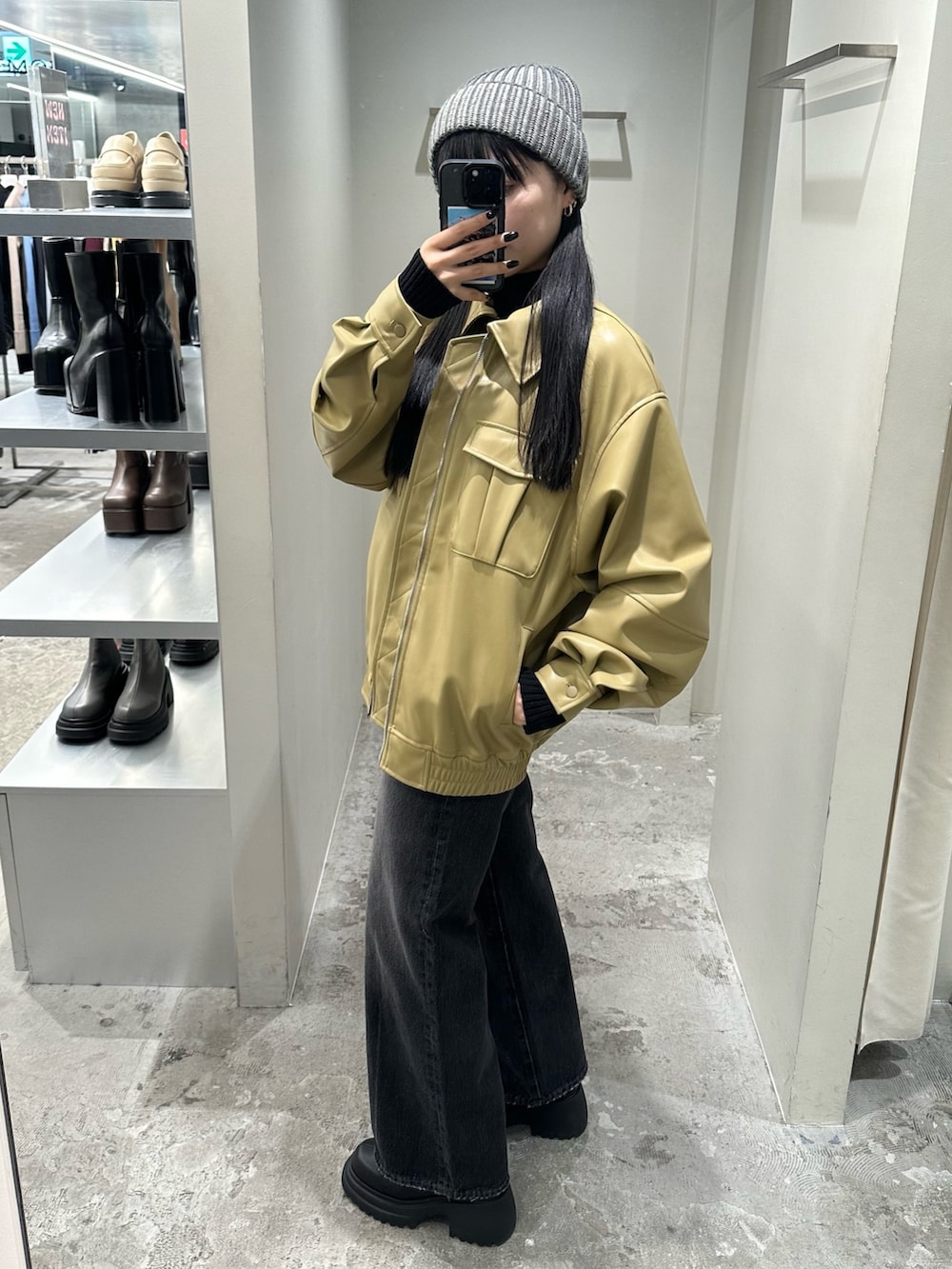 ブラック系のデニムパンツ、イエロー系のブルゾン、ブラック系のニット/セーターを着用したレディースの冬コーディネートの2枚目の写真