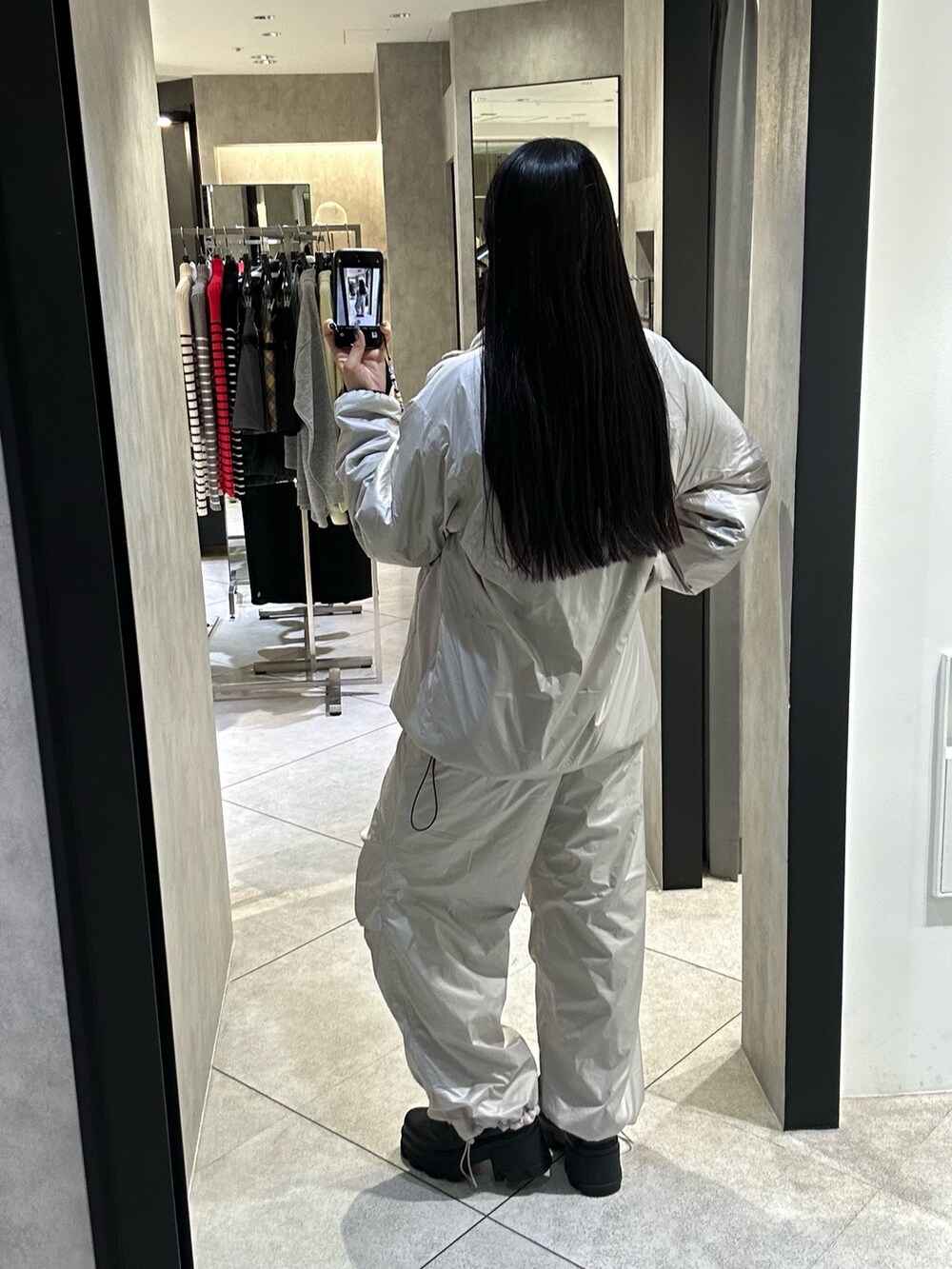 ホワイト系のブルゾン、ホワイト系のその他パンツ、ブラック系のブーツを着用したレディースの秋コーディネートの3枚目の写真