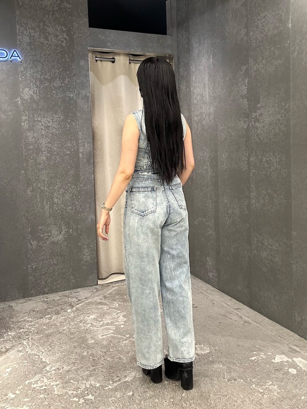 ブルー系のデニムパンツ、ブルー系のキャミソール、ブラック系のサンダルを着用したレディースの夏コーディネートの3枚目の写真