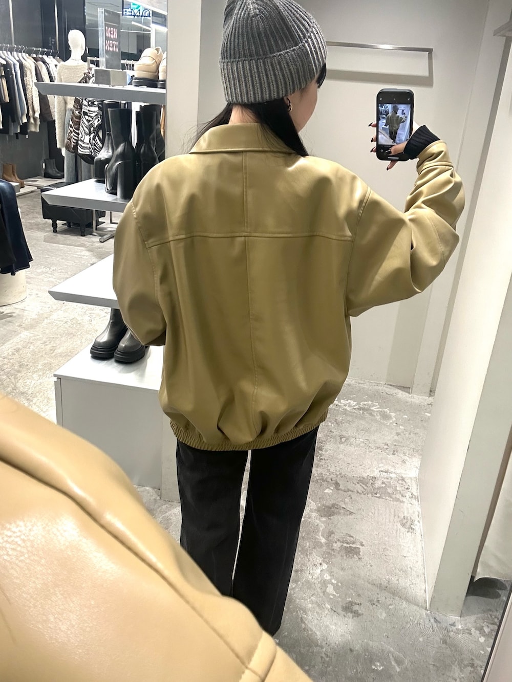 ブラック系のデニムパンツ、イエロー系のブルゾン、ブラック系のニット/セーターを着用したレディースの冬コーディネートの4枚目の写真