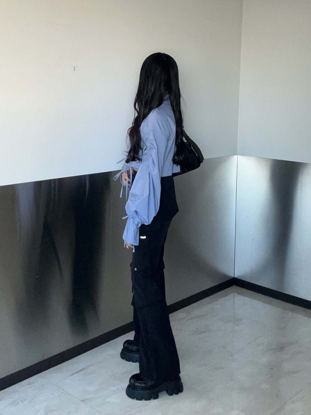 ブラック系のその他パンツ、ブルー系のシャツ/ブラウス、ブラック系のローファーを着用したレディースの冬コーディネートの2枚目の写真