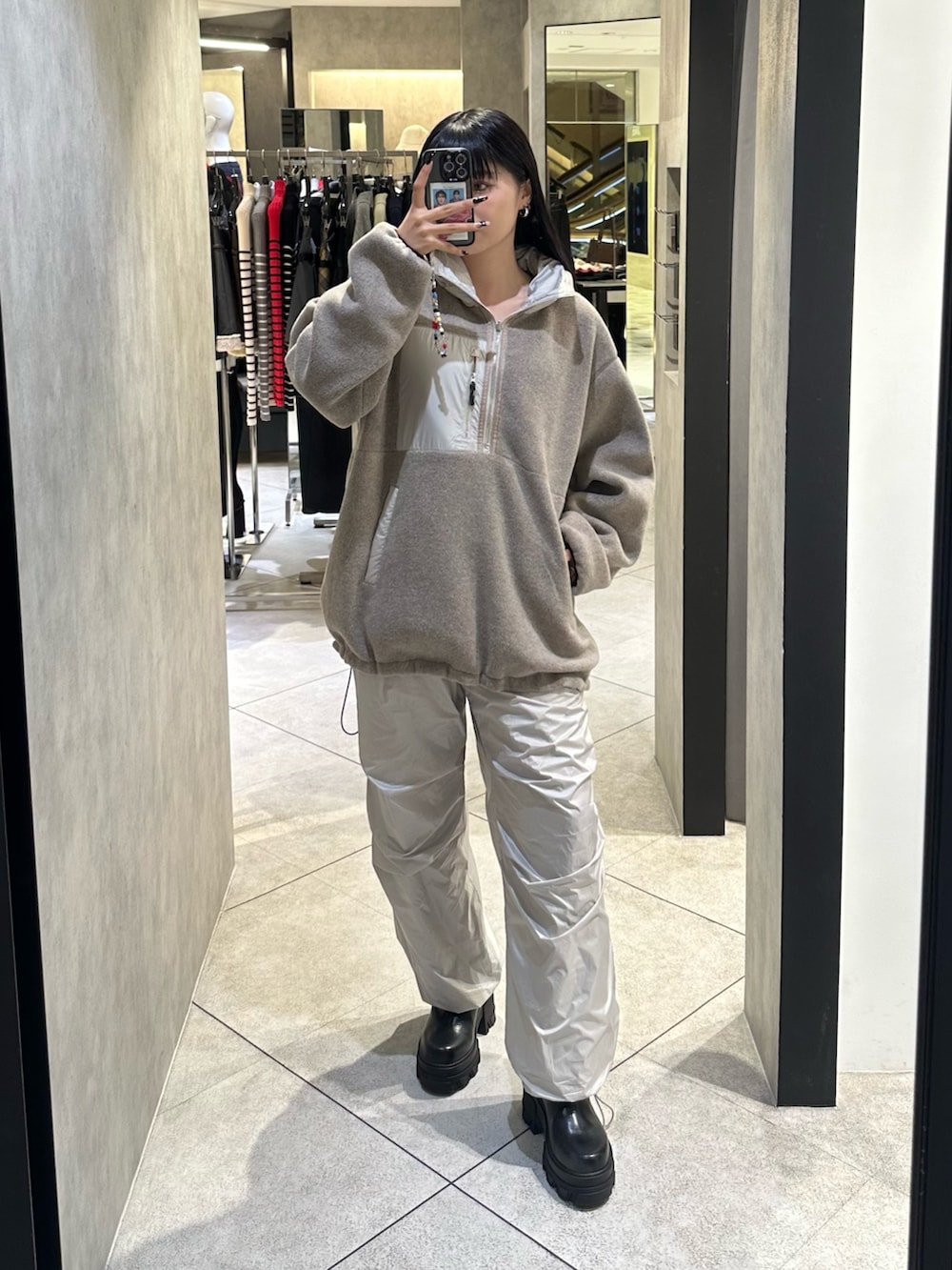 ホワイト系のブルゾン、ホワイト系のその他パンツ、ブラック系のブーツを着用したレディースの秋コーディネートの6枚目の写真