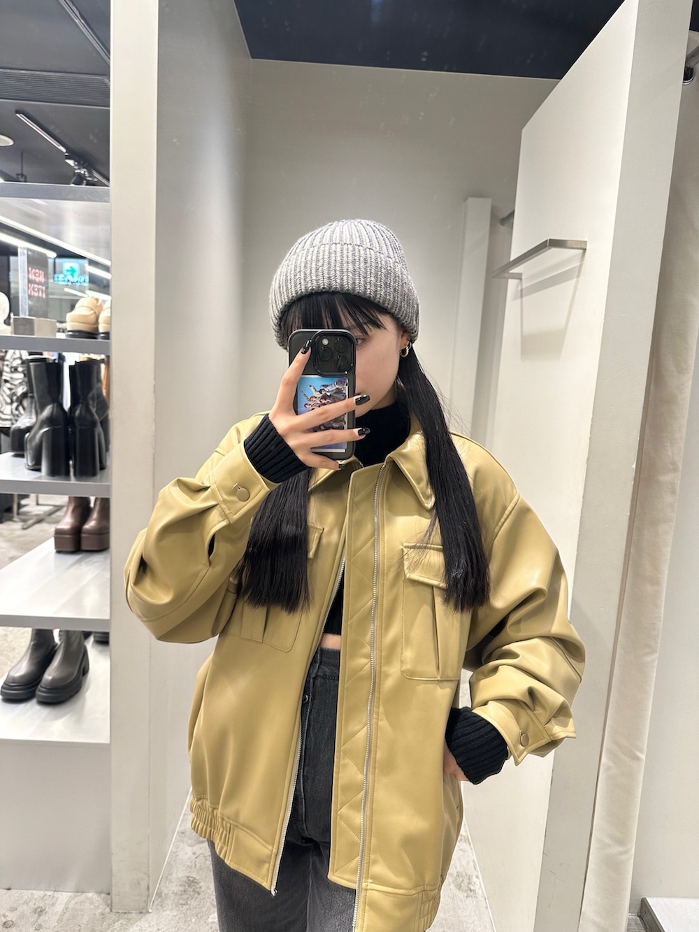 ブラック系のデニムパンツ、イエロー系のブルゾン、ブラック系のニット/セーターを着用したレディースの冬コーディネートの5枚目の写真