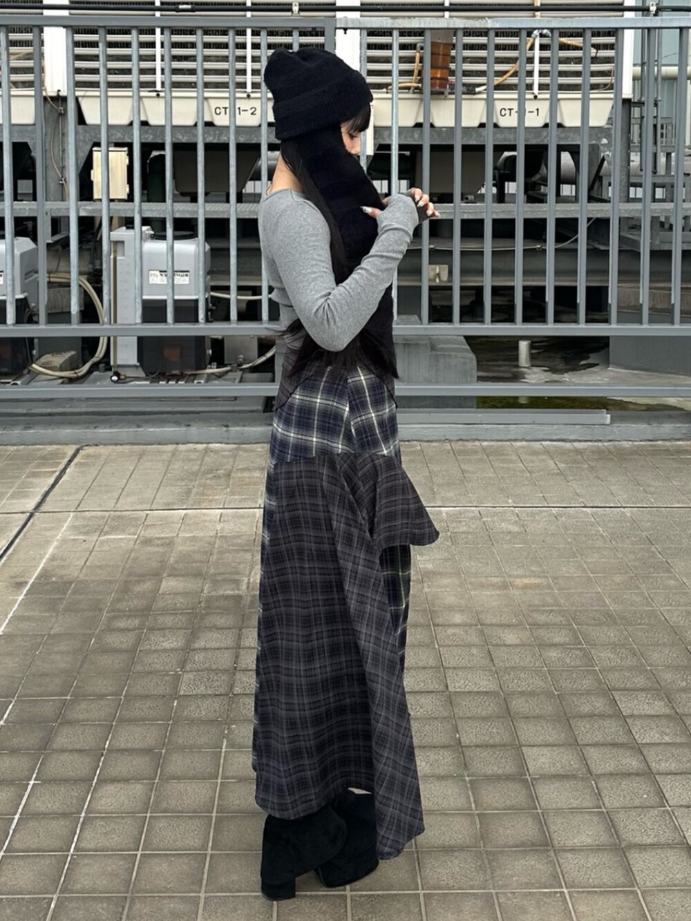 ブルー系のスカート、ブラック系のブーツ、グレー系のTシャツ/カットソーを着用したレディースの秋コーディネートの2枚目の写真