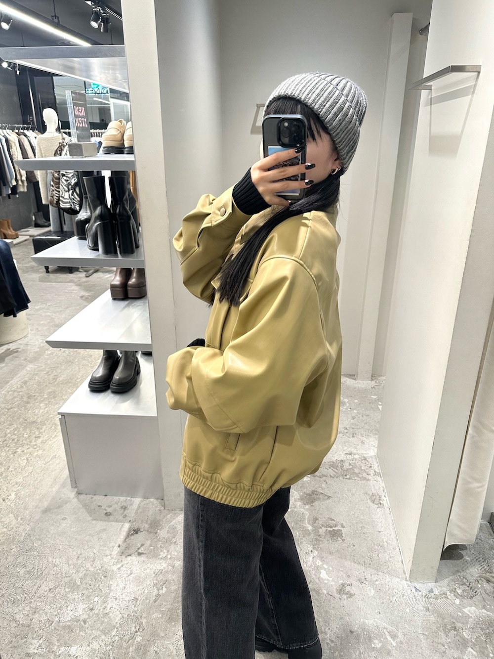 ブラック系のデニムパンツ、イエロー系のブルゾン、ブラック系のニット/セーターを着用したレディースの冬コーディネートの3枚目の写真