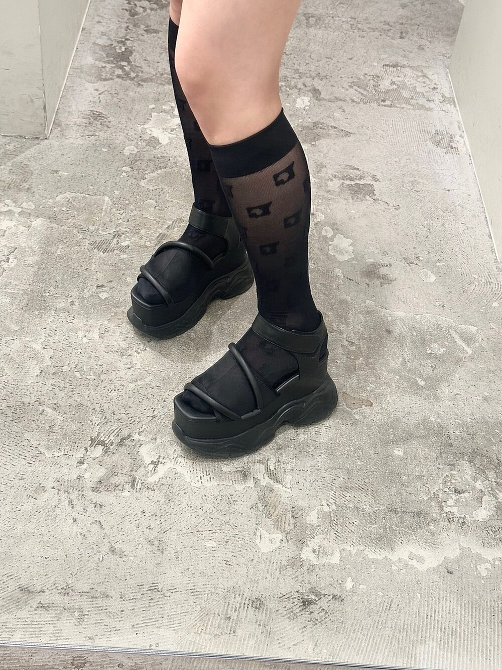 ブルー系のデニムスカート、ブラック系のTシャツ/カットソー、ブラック系のサンダルを着用したレディースの春コーディネートの5枚目の写真