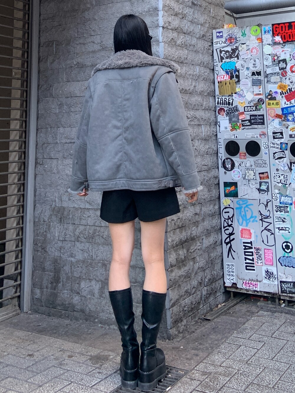 グレー系のムートンコート、ブルー系のニット/セーター、ブラック系のその他パンツを着用したレディースの冬コーディネートの4枚目の写真