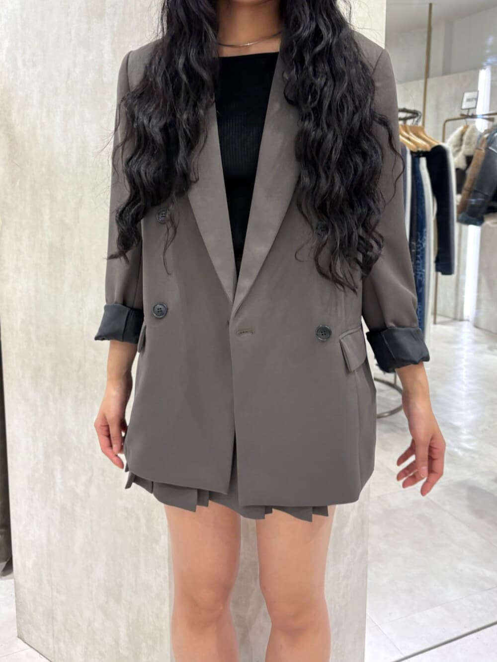 ブラック系のブーツ、グレー系のテーラードジャケット、グレー系のスカートを着用したレディースの冬コーディネートの5枚目の写真