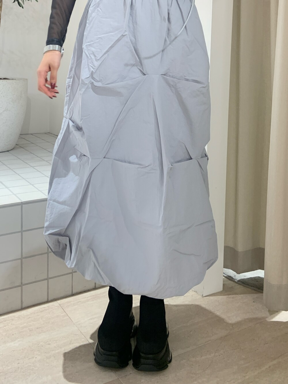 ホワイト系のTシャツ/カットソー、ブルー系のスカート、ブラック系のブーツを着用したレディースの春コーディネートの6枚目の写真