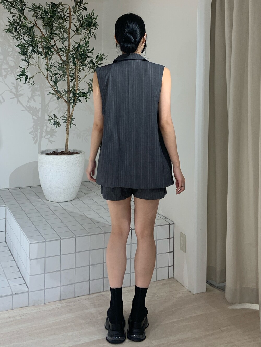 グレー系のベスト、ホワイト系のタンクトップ、グレー系のその他パンツを着用したレディースの夏コーディネートの4枚目の写真