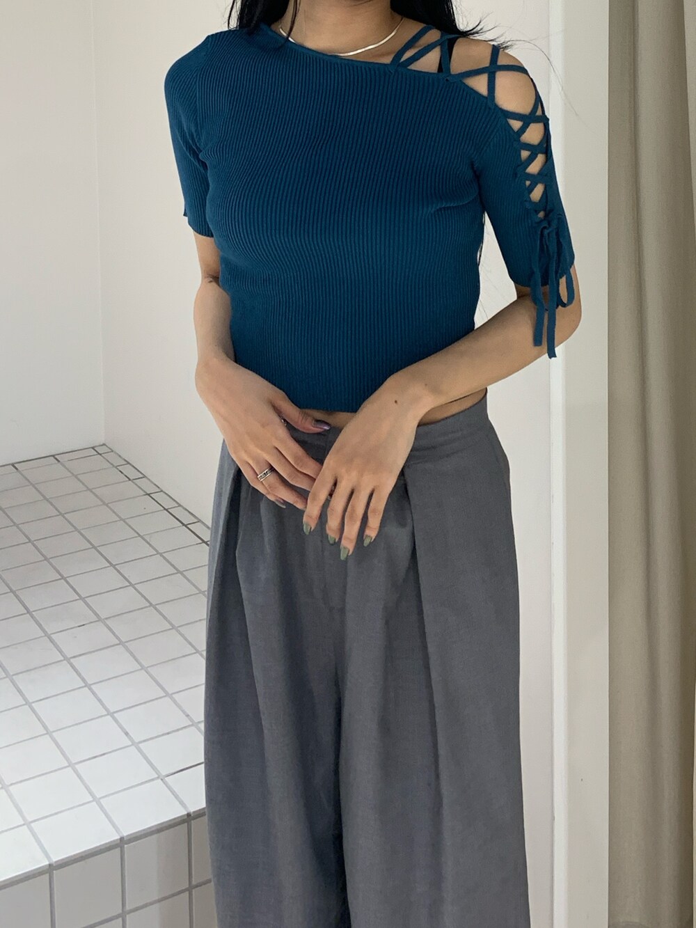 ブルー系のニット/セーター、グレー系のその他パンツ、ブラック系のサンダルを着用したレディースの夏コーディネートの5枚目の写真