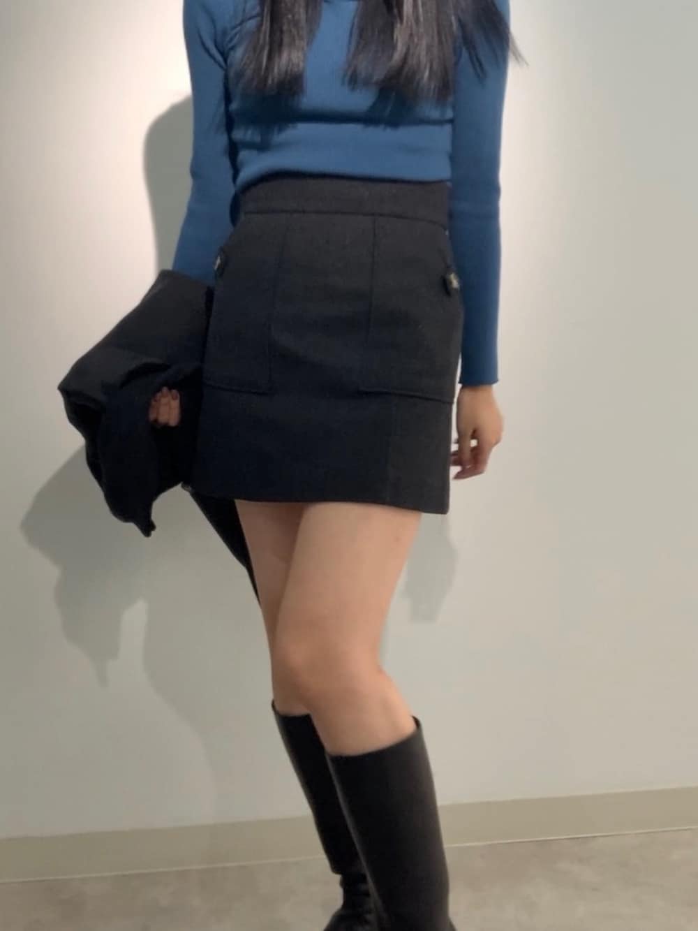 グレー系のテーラードジャケット、ブルー系のニット/セーター、グレー系のスカートを着用したレディースの秋コーディネートの4枚目の写真