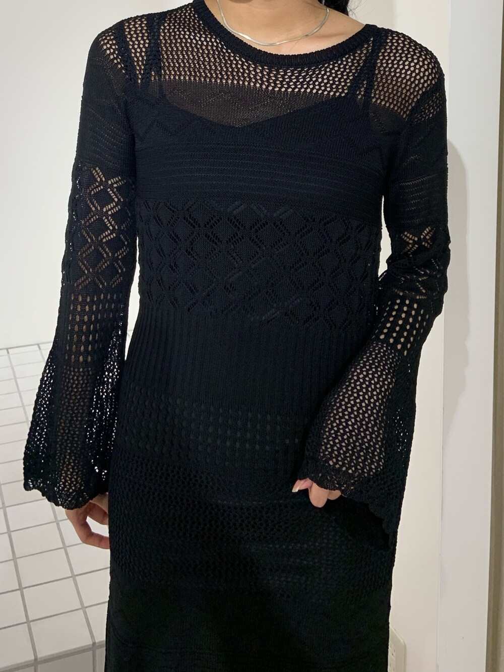 ブラック系のワンピース、ブラック系のブーツを着用したレディースの秋コーディネートの5枚目の写真