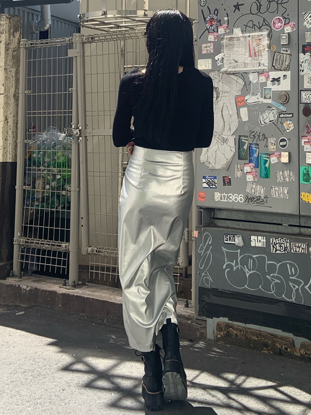 ブラック系のニット/セーター、シルバー系のスカート、ブラック系のブーツを着用したレディースの秋コーディネートの4枚目の写真