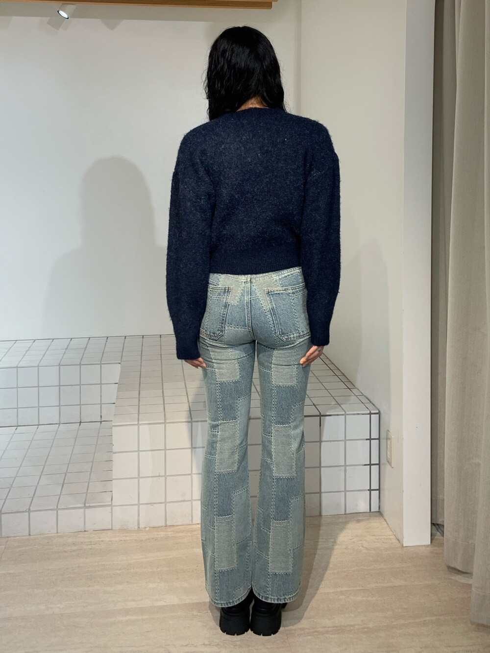 ブルー系のニット/セーター、ブルー系のデニムパンツを着用したレディースの秋コーディネートの3枚目の写真