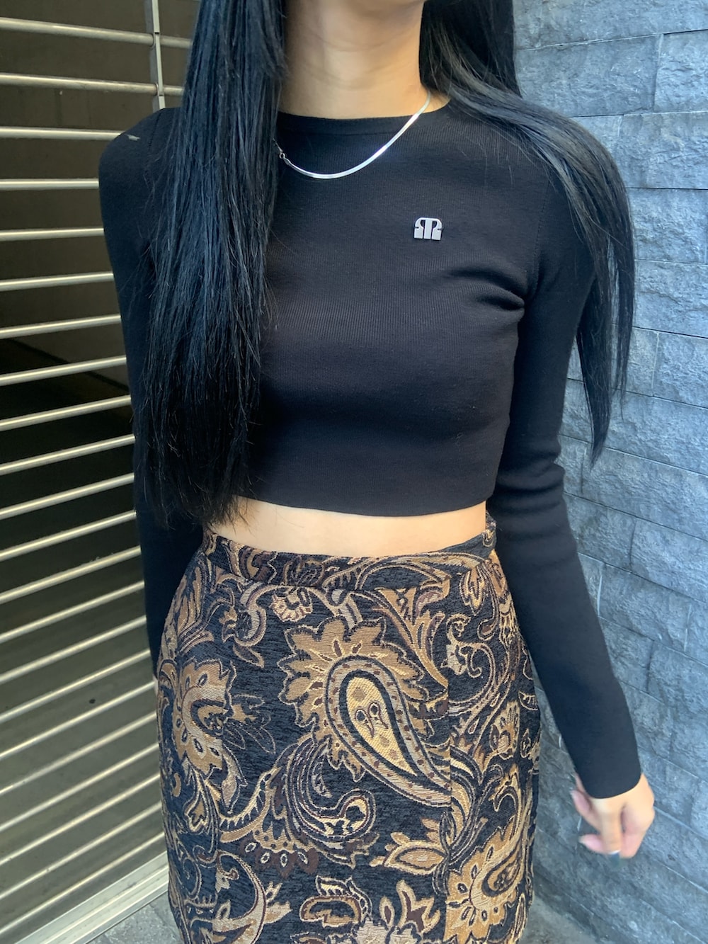 ブラック系のニット/セーター、ブラック系のスカート、ブラック系のブーツを着用したレディースの冬コーディネートの5枚目の写真