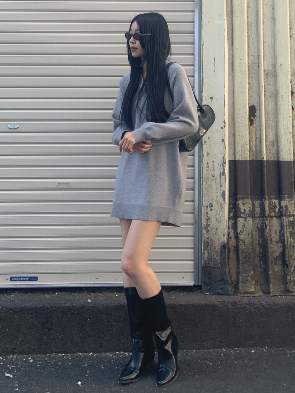 ブラック系のボストンバッグ、グレー系のワンピース、ブラック系のブーツを着用したレディースの冬コーディネートの2枚目の写真