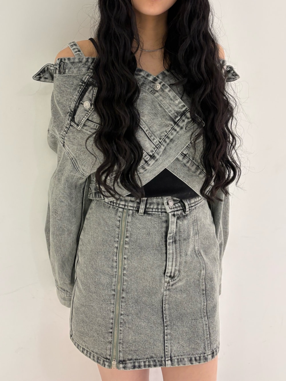 グリーン系のデニムジャケット、グリーン系のデニムスカート、ブラック系のブーツを着用したレディースの冬コーディネートの4枚目の写真