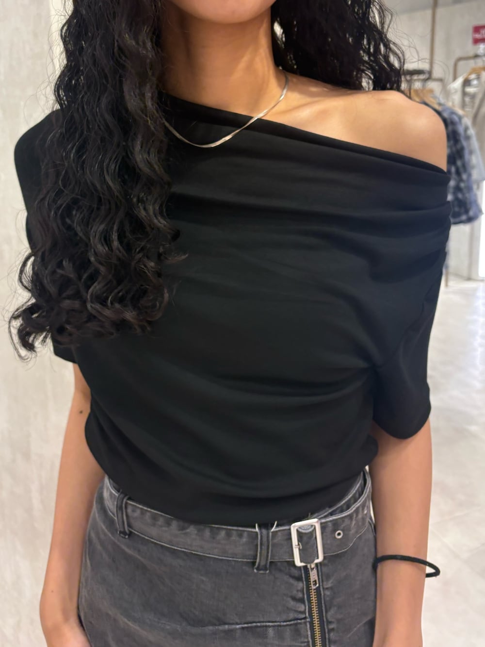 ブラック系のTシャツ/カットソー、ブラック系のデニムスカート、ブラック系のブーツを着用したレディースの夏コーディネートの4枚目の写真