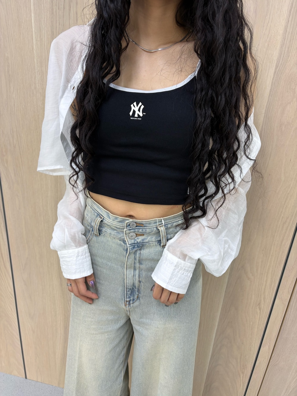 ブラック系のキャミソール、ホワイト系のシャツ/ブラウス、ブルー系のデニムパンツを着用したレディースの春コーディネートの5枚目の写真