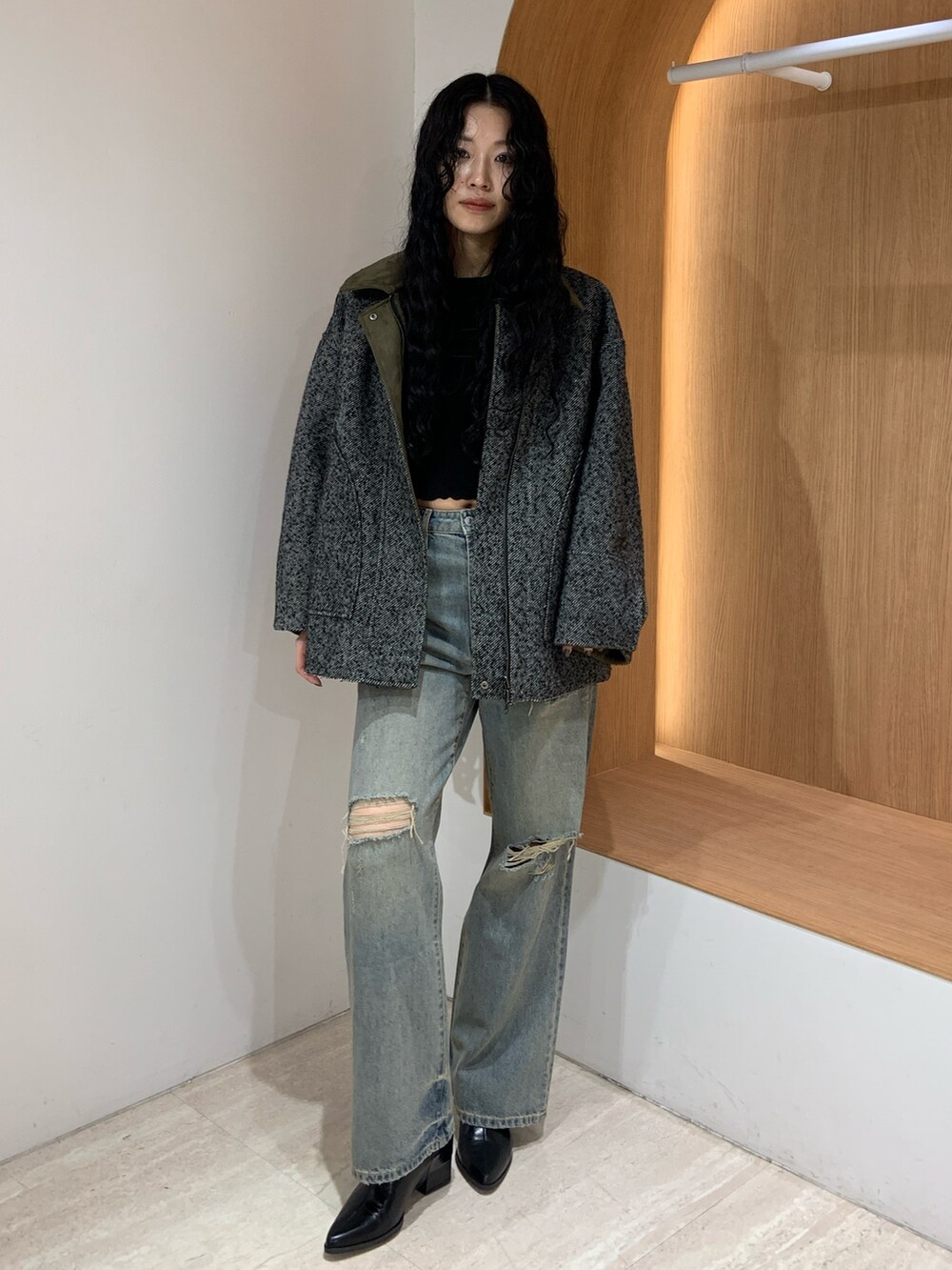 ブルー系のデニムパンツ、グリーン系のテーラードジャケットを着用したレディースの秋コーディネートの2枚目の写真