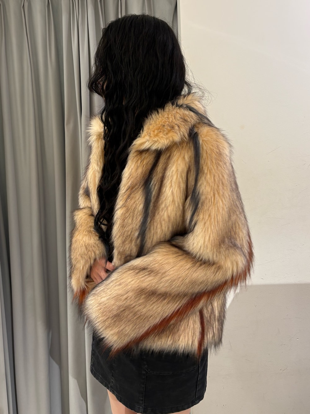 その他のステンカラーコート、ブラック系のスカート、ブラック系のブーツを着用したレディースの冬コーディネートの4枚目の写真