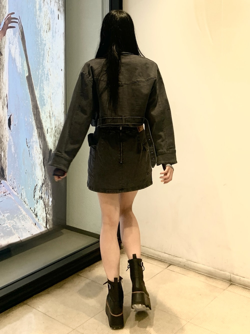 ブラック系のデニムジャケット、ブルー系のTシャツ/カットソー、ブラック系のスカートを着用したレディースの秋コーディネートの3枚目の写真