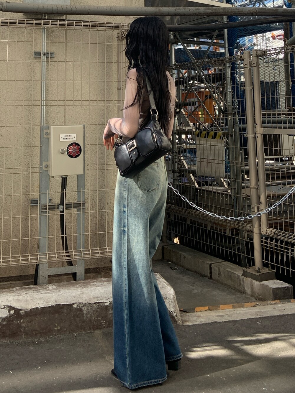 グレー系のTシャツ/カットソー、ブラック系のハンドバッグ、ブルー系のデニムパンツを着用したレディースの春コーディネートの3枚目の写真