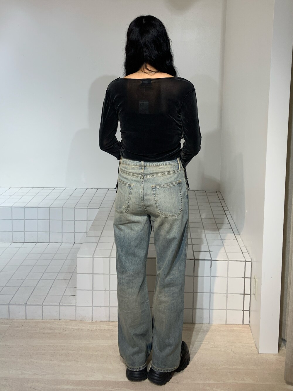 ブラック系のTシャツ/カットソー、ブルー系のデニムパンツを着用したレディースの秋コーディネートの3枚目の写真