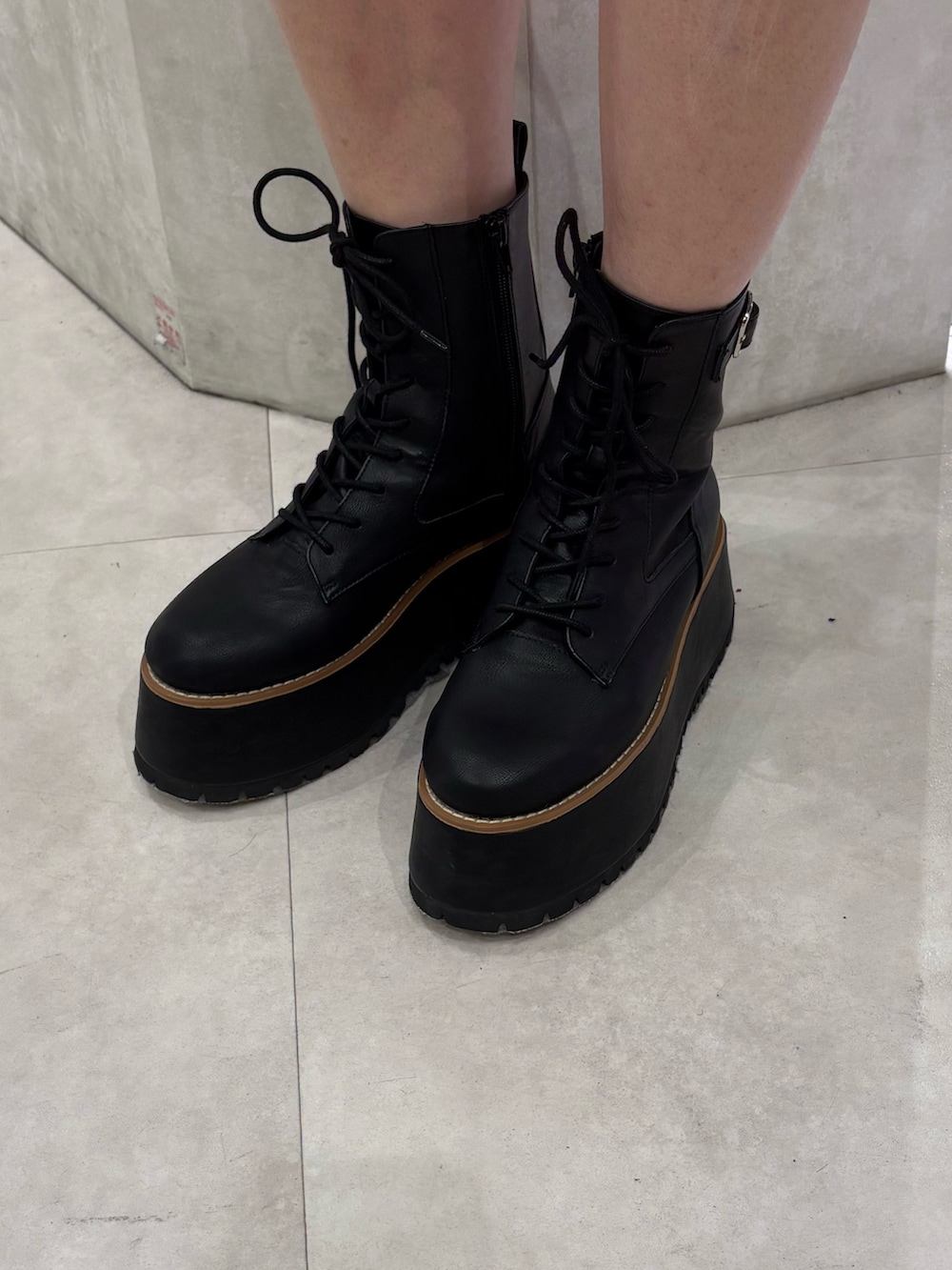 グレー系のニット/セーター、ブラック系のその他パンツ、ブラック系のブーツを着用したレディースの春コーディネートの5枚目の写真