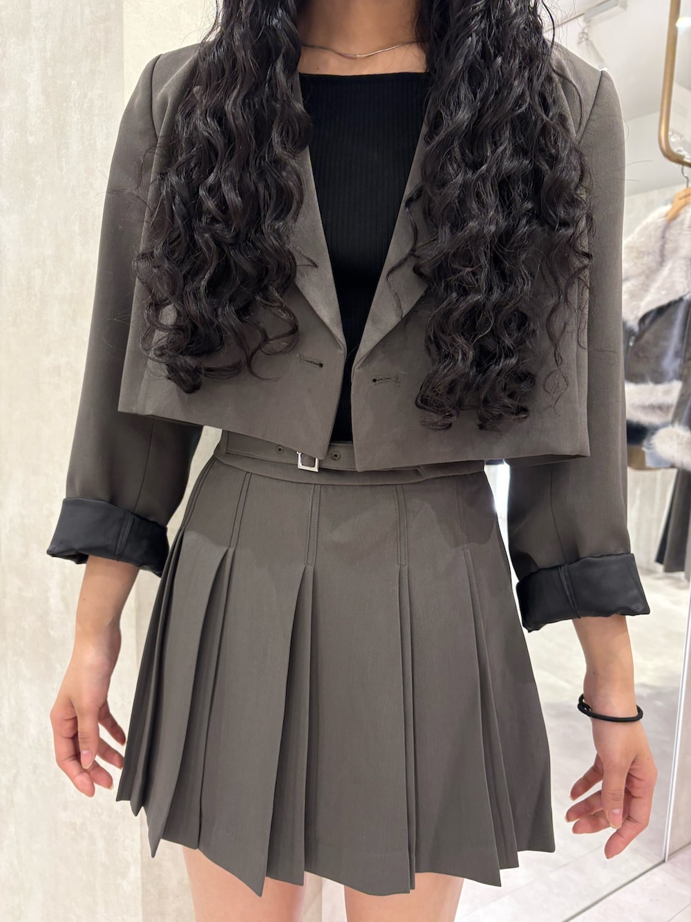 グレー系のテーラードジャケット、グレー系のスカートを着用したレディースの冬コーディネートの4枚目の写真