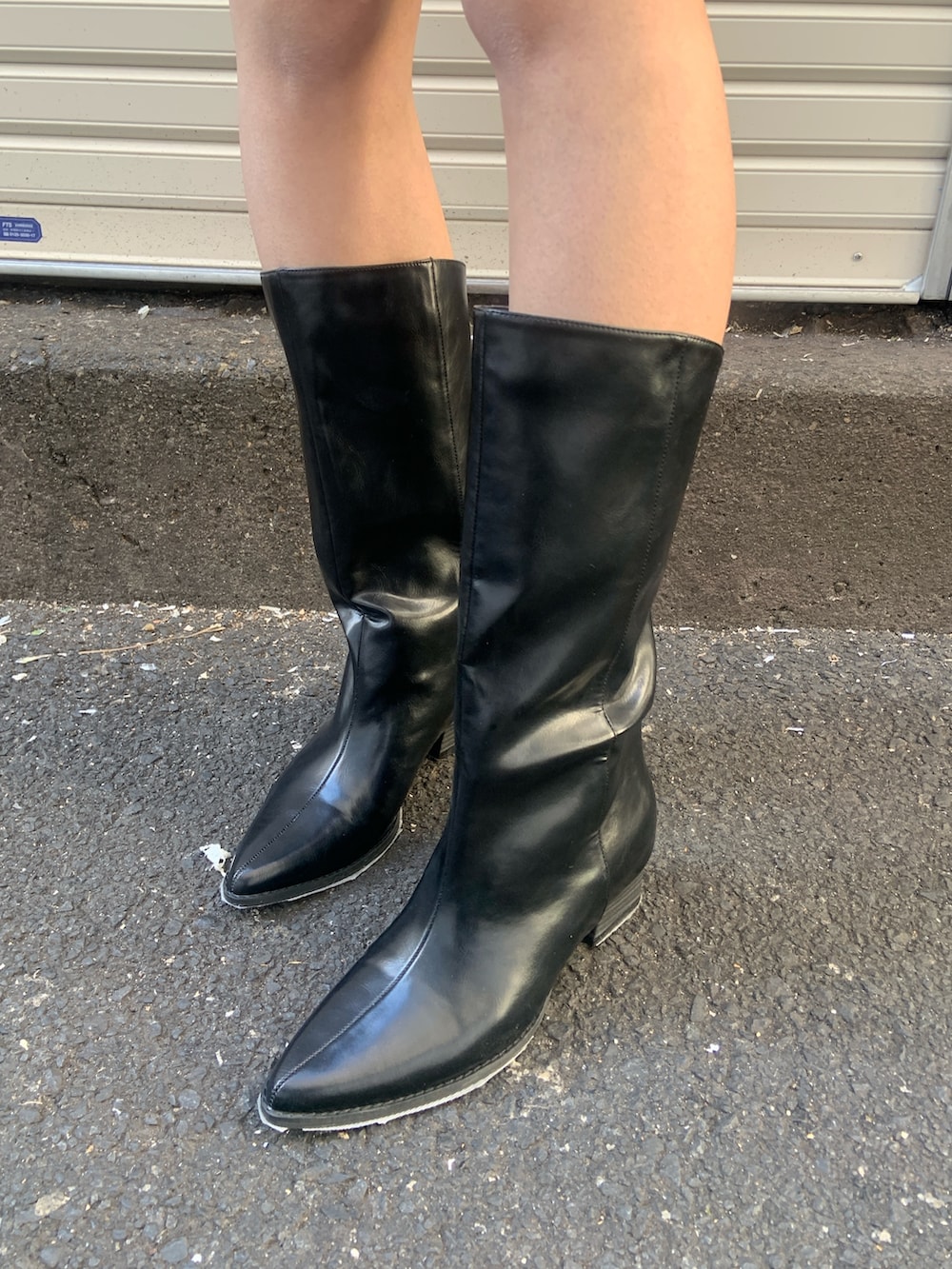 ブラック系のブルゾン、ブラック系のスカート、グレー系のパーカーを着用したレディースの冬コーディネートの6枚目の写真