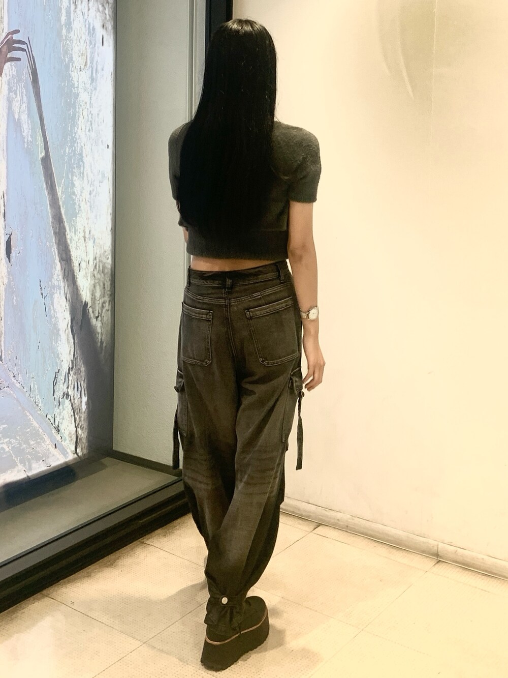 グレー系のニット/セーター、ブラック系のデニムパンツ、ブラック系のブーツを着用したレディースの秋コーディネートの3枚目の写真