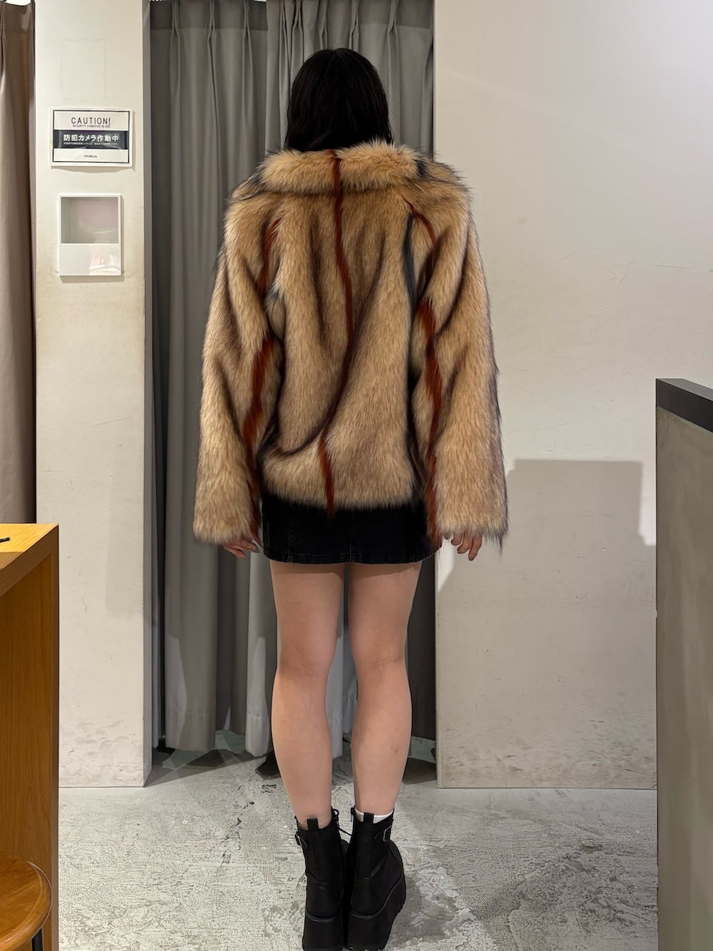 その他のステンカラーコート、ブラック系のスカート、ブラック系のブーツを着用したレディースの冬コーディネートの3枚目の写真