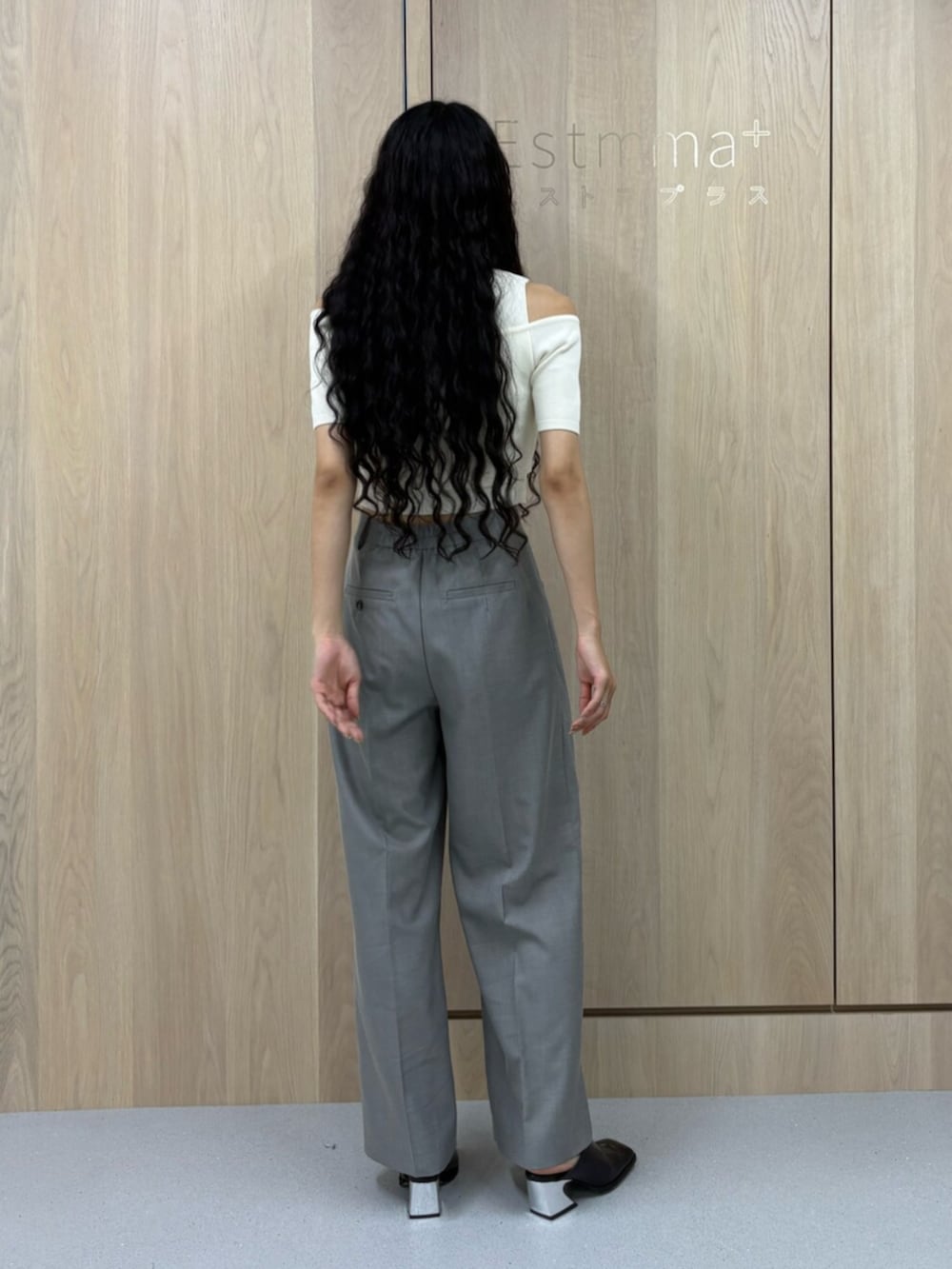 ブラック系のパンプス、グレー系のスラックス、ホワイト系のニット/セーターを着用したレディースの夏コーディネートの3枚目の写真