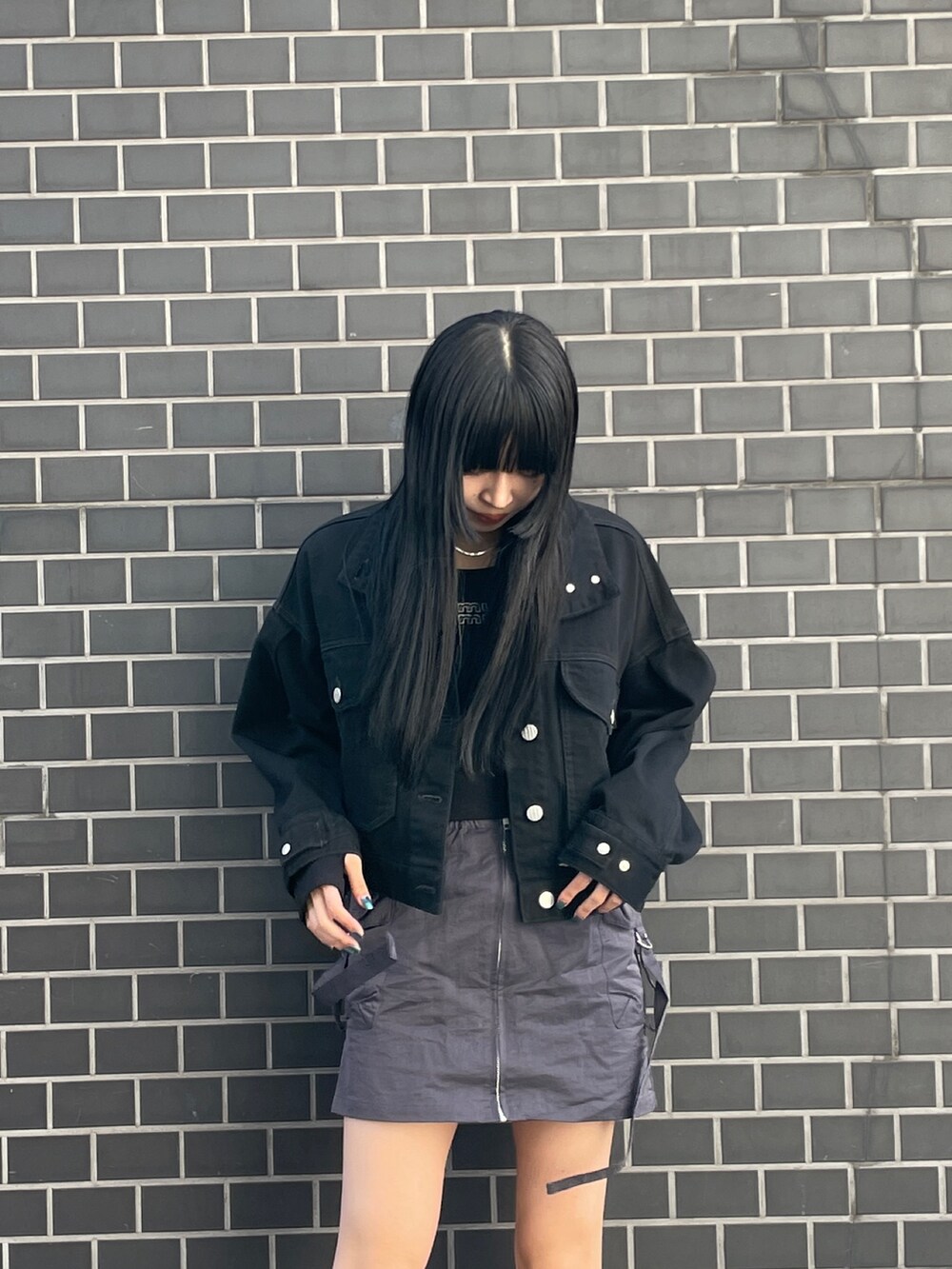 ブラック系のデニムジャケット、ブラック系のTシャツ/カットソー、グレー系のスカートを着用したレディースの冬コーディネートの3枚目の写真